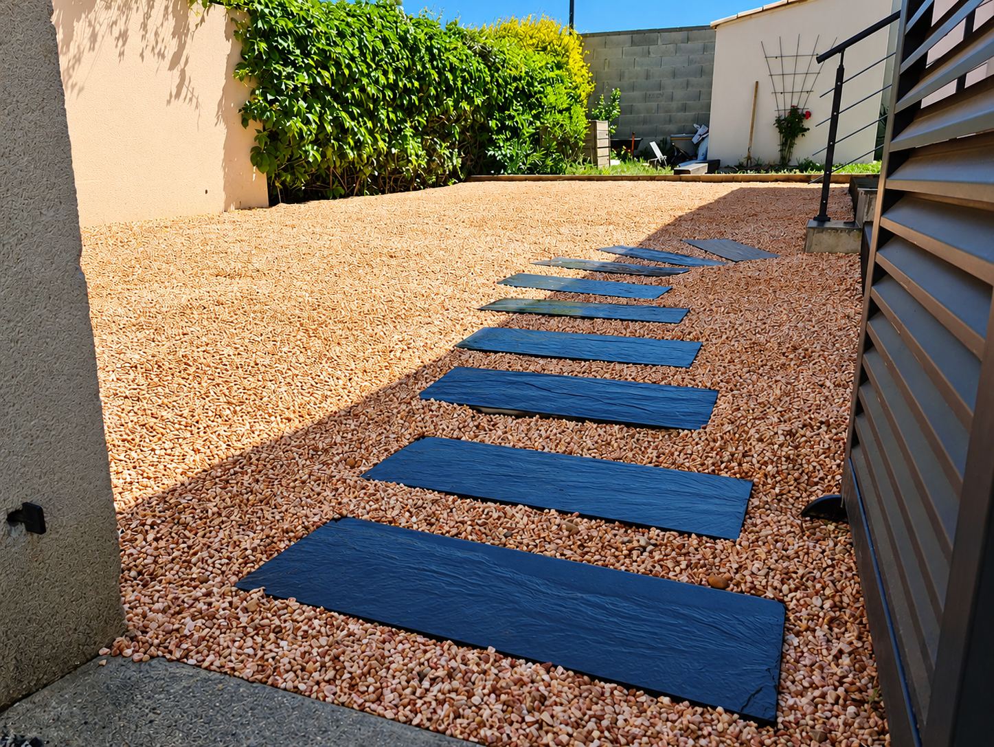 Allée de jardin en gravier rose avec dalles d'ardoise