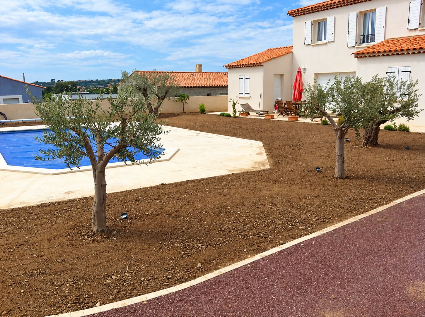 Jardin fraîchement aménagé avec oliviers et piscine devant une villa provençale