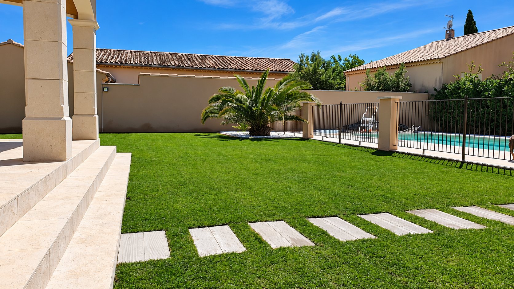 Jardin avec pelouse, pas japonais, palmier et piscine clôturée