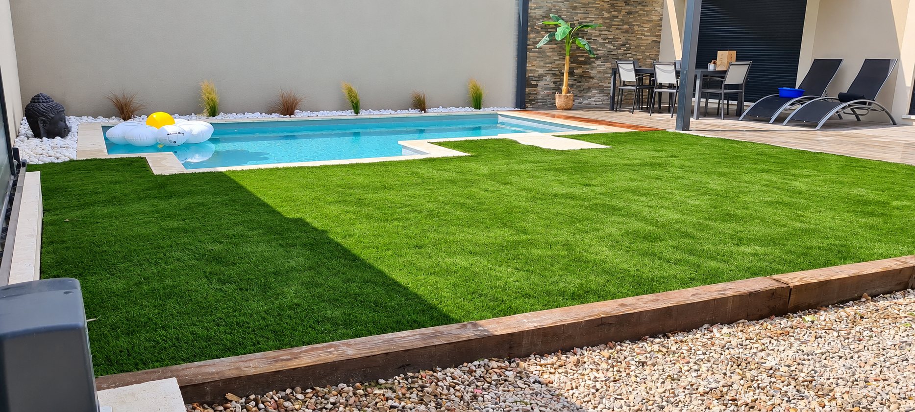 Jardin avec pelouse synthétique, piscine et terrasse avec transats