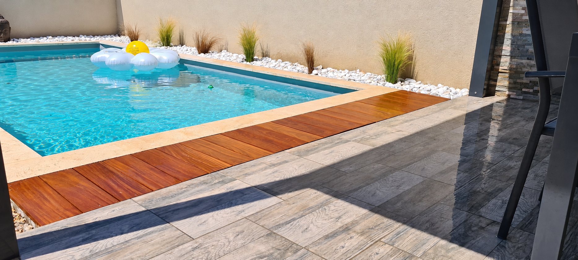 Piscine rectangulaire avec terrasse en bois exotique et carrelage effet bois