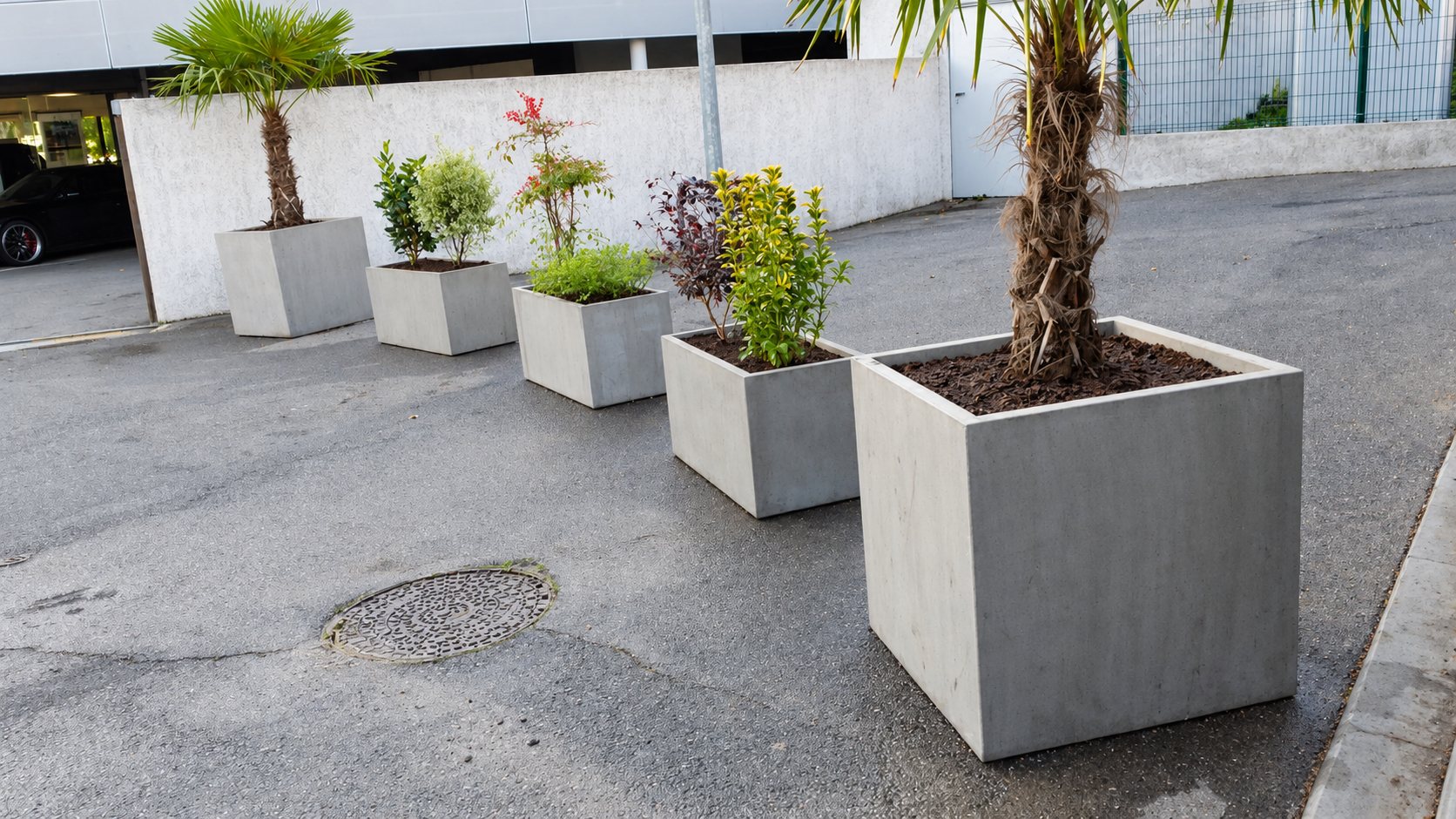 Rangée de grands bacs à plantes carrés en béton gris